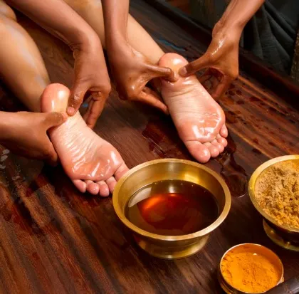 A closer look at the Padabhyanga foot massage in progress. This treatment uses warm herbal oils and specific techniques to stimulate nerve endings, improve circulation, and release negative energy.