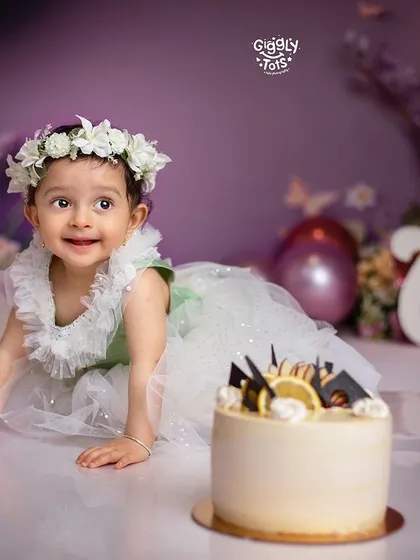 A sweet smile from the birthday girl as she crawls towards her cake, ready for the smashing to begin.