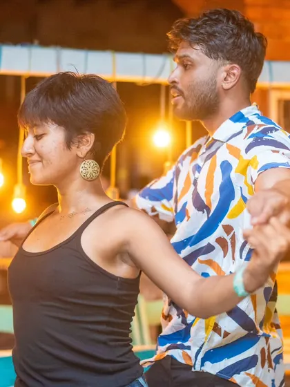 A stylish and focused pair moving in sync. The background lights create a beautiful, warm ambiance.