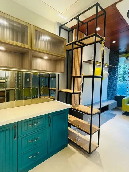 A teal crockery unit with classic grooved shutters and a mirrored backsplash, part of a larger kitchen and dining display.