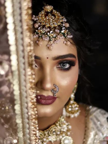 A close-up shot that uses the dupatta to create a sense of mystery and allure, focusing on the dramatic eye makeup.