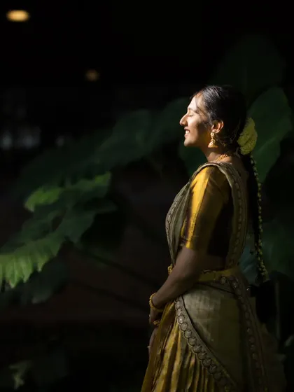 A bride bathed in soft, dappled sunlight. Her happy, serene expression is the focus of this beautiful and natural portrait.