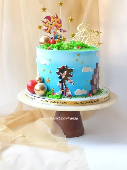 A full view of the Sonic the Hedgehog cake on its stand, showcasing all the toppers and decorations together.