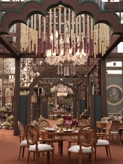 Another view of the dining area, highlighting the interplay between the floral chandeliers, the traditional arches, and the elegant table settings.