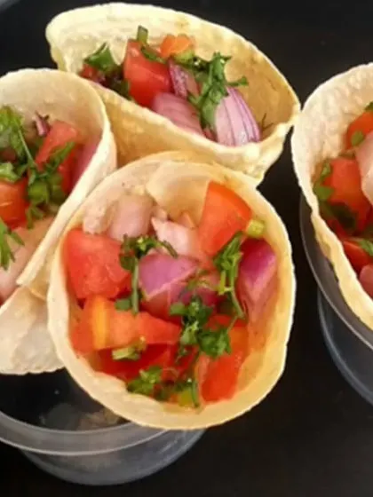 A creative twist on a classic Indian snack: masala papad served in a cone. Filled with a fresh mix of chopped onions, tomatoes, and cilantro, this is a fun and easy-to-eat appetizer for a Sangeet or Mehendi party.