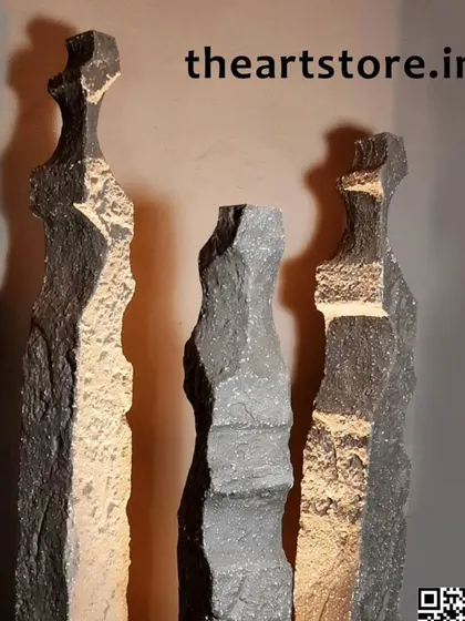These tall, slender sculptures with a rough, textured finish are perfect for adding vertical interest to a space. The interplay of light and shadow highlights their unique form.