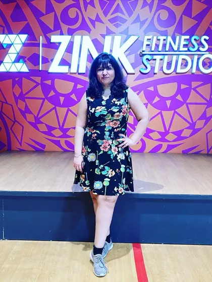 A member posing in front of our signature Zink wall. It's the perfect photo spot to capture that post-workout glow and feeling of accomplishment.
