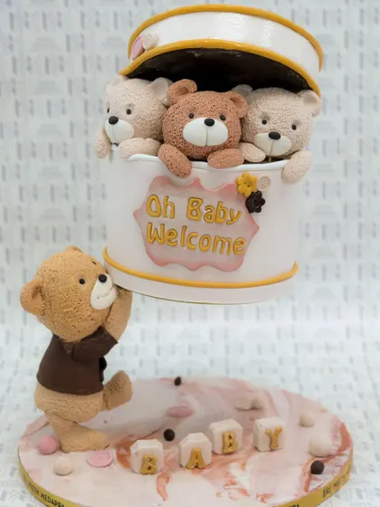 Oh Baby, Welcome! This gravity-defying baby shower cake features a box of adorable teddy bears being lifted by another bear.