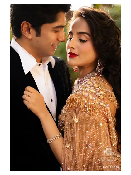 A romantic close up of the couple. The makeup is classic and elegant, with a focus on the bold red lip and perfectly defined eyes, creating a timeless and passionate look.