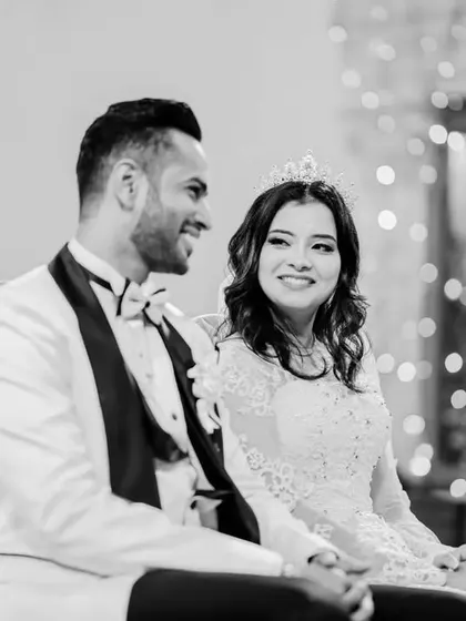 A candid black and white moment from the church ceremony. The bokeh from the background lights adds a magical feel to this happy portrait.