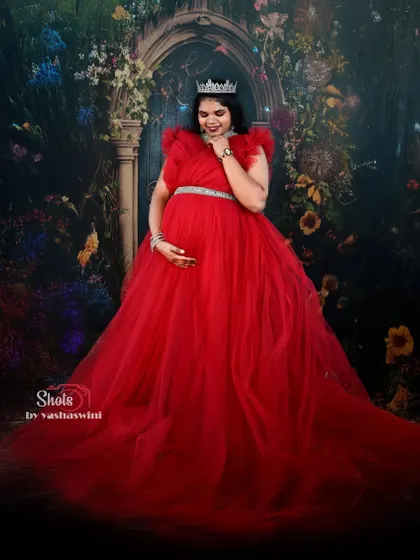 A fairytale moment in our red ball gown. This is a perfect rental choice for creating a magical and royal-themed maternity photoshoot.