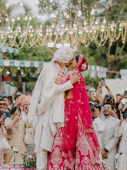 The first kiss as husband and wife, surrounded by cheering family and friends. This is a pinnacle moment, filled with emotion and celebration.