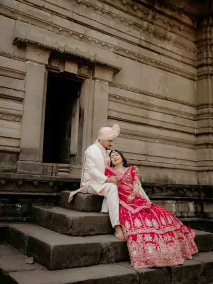 A serene portrait of the couple resting on the temple steps after their wedding. It’s a quiet moment of peace and togetherness.