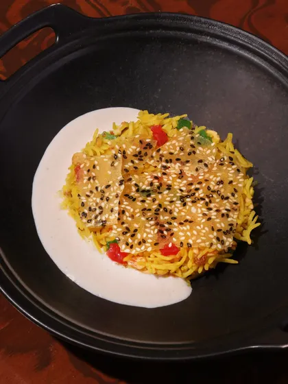 Chawal ka Zarda, a traditional sweet rice dish, layered with a sesame seed crisp and softened by almond milk. A dessert that surprises in every texture.