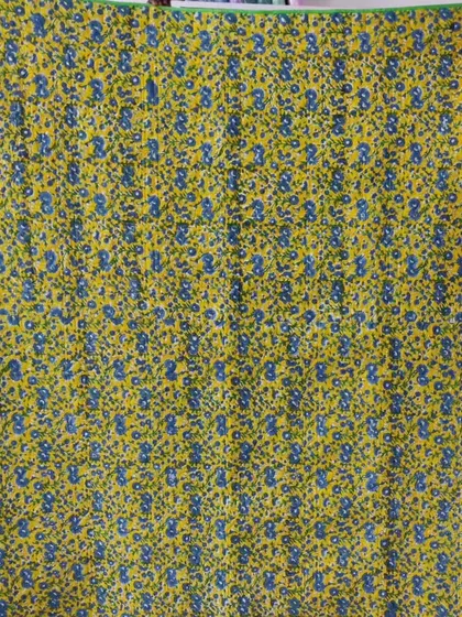 The backing of a quilt, featuring a fun yellow and blue floral print.