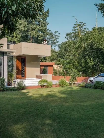 **The Glow House, Ahmedabad:** The home is carefully placed on its plot to maximize garden views and create a sense of arrival. The clean, modern form of the house contrasts with the lush, organic landscape, creating a balanced and peaceful residential environment.