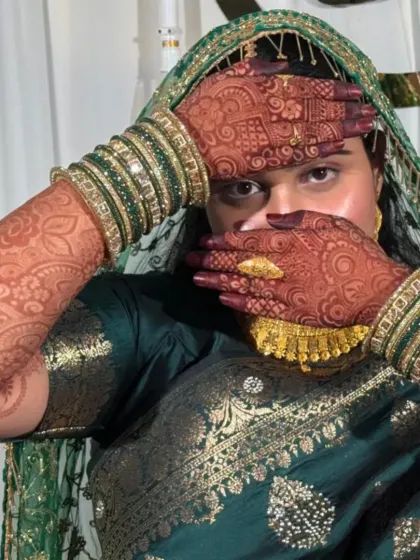The bride showing off her stunning henna stain with her beautiful green saree and bangles. This is the complete bridal look.