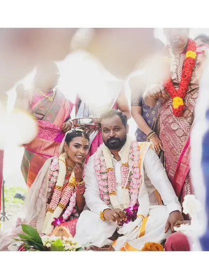 A candid portrait of the couple during their wedding ceremony. The frame is filled with the presence of family, capturing the shared joy and emotion of the moment.