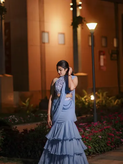 A modern take on the half saree, this powder blue ruffled lehenga is paired with an embroidered halter-neck blouse.
