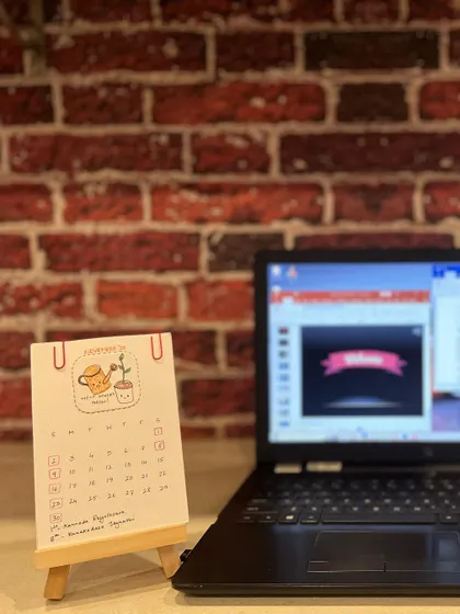 My hand-drawn calendar sitting on a work-from-home desk, adding a bit of cheer next to a laptop.