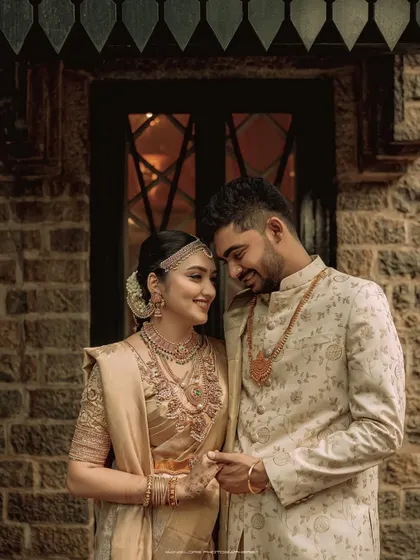 A beautiful moment of connection between the bride and groom. Their coordinated golden attire shines in this elegant portrait taken at Chamaravarjra.