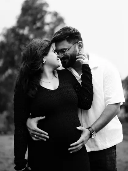 An intimate black and white close-up. The couple touches foreheads, their faces close, capturing a moment of deep connection and tenderness.