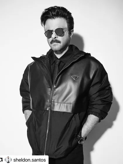 This black and white photo of Anil Kapoor showcases a sleek, modern hairstyle that works perfectly with his edgy outfit.