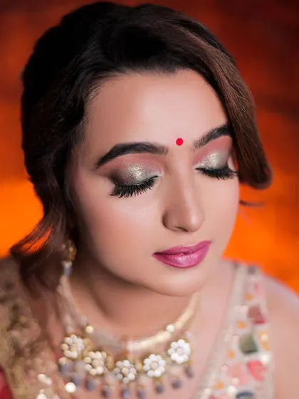 A close-up beauty shot focusing on the model's stunning eye makeup and serene expression.