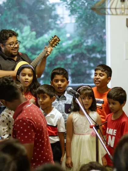 A beautiful group shot from our summer camp recital, with a teacher leading the kids on guitar.