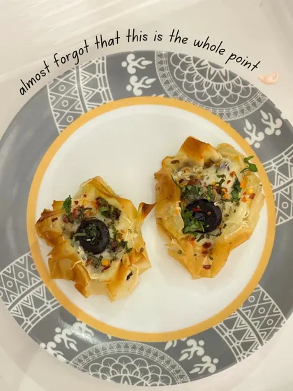 A plate of our crispy, savory filo pastry cups, filled with a delicious mixture and topped with olives and herbs. A perfect pass-around snack.