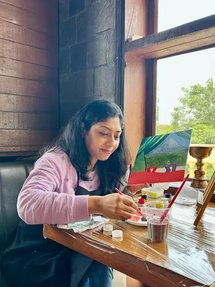 A participant fully absorbed in her mountain landscape painting.
