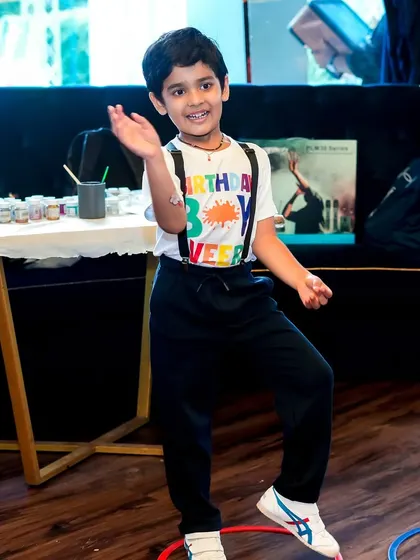 The birthday boy, Veer, enjoying his art-themed party. I organize various activities, including games like ring toss, to keep the creative energy flowing.