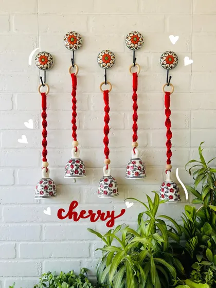 Our 'Cherry' macrame ceramic bells in a bold red color. This set of five is perfect for making a statement and adding a vibrant touch to your home decor.