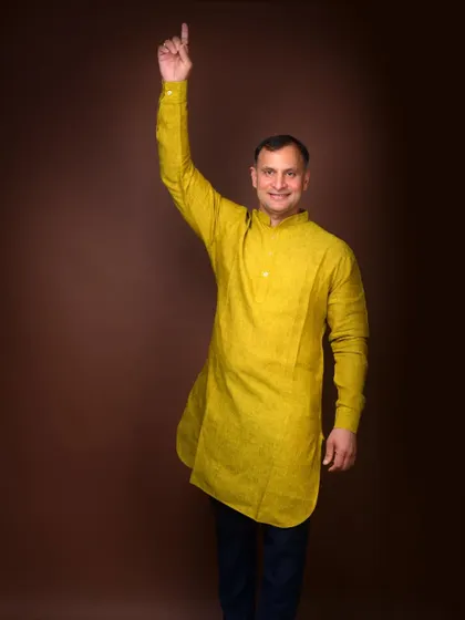 A dynamic portrait for a political campaign, with a gesture that signifies vision and looking upwards. The bright kurta adds a touch of vibrancy.
