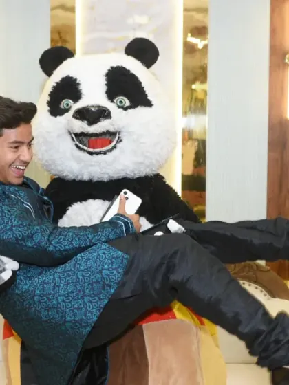 A playful moment as a guest jokes around with the panda mascot.
