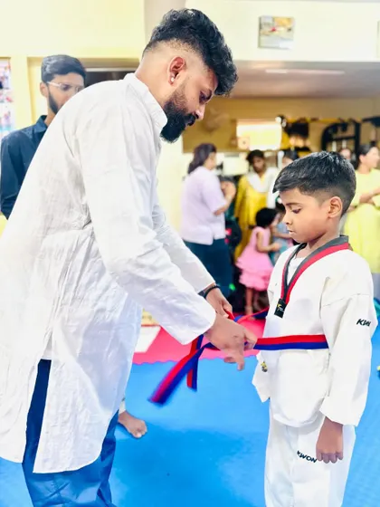 Awarding a red and blue belt, signifying a higher level of skill and experience.