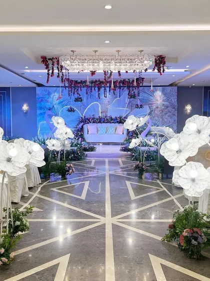 The full view of the 'Illuminated Garden' setup, with glowing floral props lining the aisle and a dramatic stage backdrop.