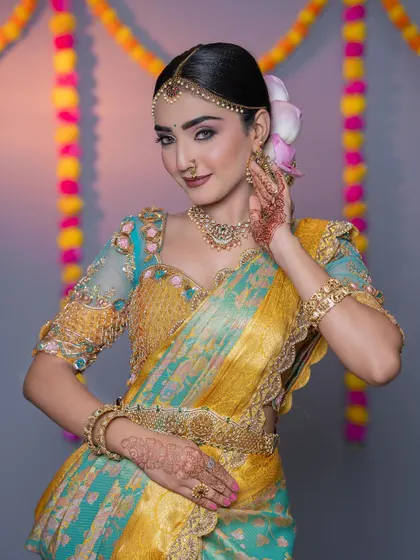 The model against a festive backdrop, looking like a perfect bride in her colorful and traditional attire.
