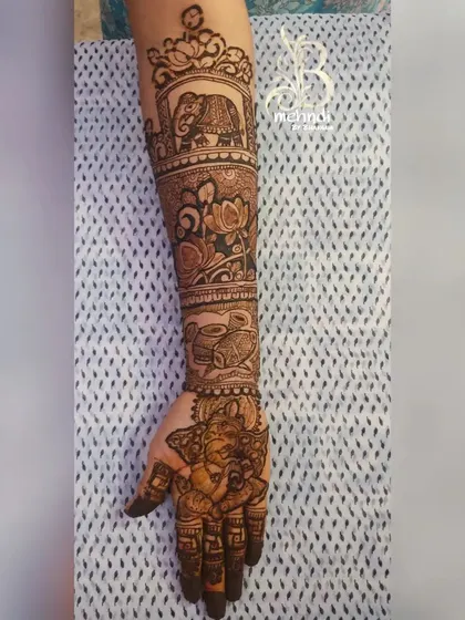 This design features an elephant in a frame on the arm, along with lotus flowers and other traditional elements.