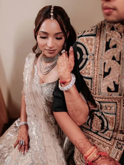 A quiet, romantic moment between the couple. The bride's makeup is soft and ethereal, with a focus on shimmery eyes and a flawless base, perfect for this intimate shot.