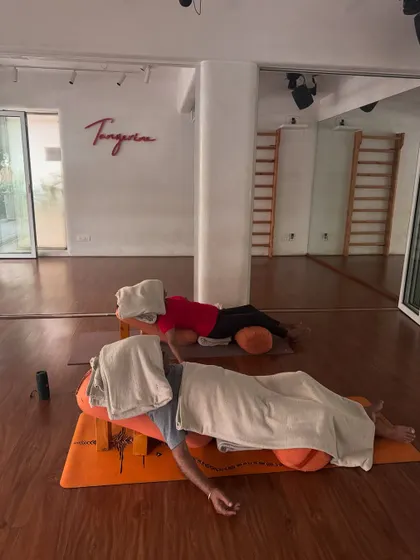 A different angle of the supported prone Savasana, showing the peaceful atmosphere of the studio as students surrender into the pose.