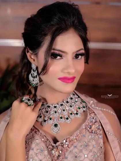 A portrait focusing on the stunning diamond and emerald necklace. The bride's pose draws all attention to the intricate details of her statement jewellery piece.