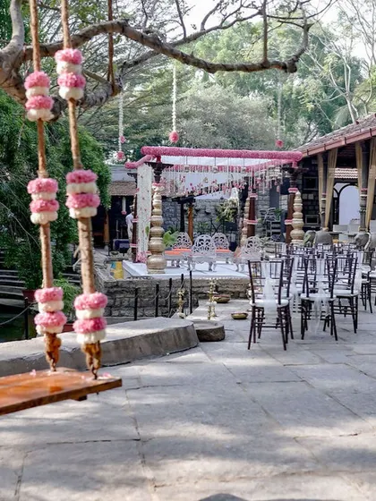 A view of the pink-themed wedding setup, with a decorated swing in the foreground.