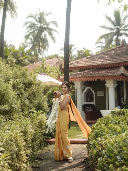A bride in a simple yellow saree for her Haldi ceremony at the Taj Holiday Village, Goa. The look is traditional, elegant, and perfectly suited for the lush, tropical surroundings.