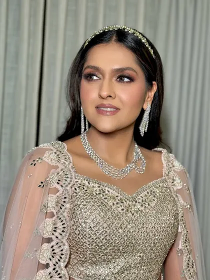 A side profile highlighting the sleek hair and dramatic diamond earrings that complete this party look.
