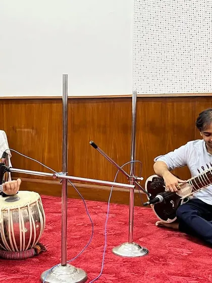 A candid moment during the All India Radio recording session. The studio environment allows for a pristine sound recording, capturing every nuance of the sitar and tabla.