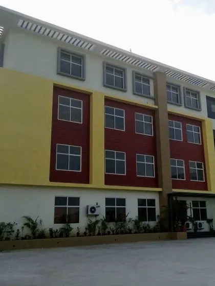 An exterior view of the Asia Pacific World School, capturing the full height of the building and its colorful architectural expression.