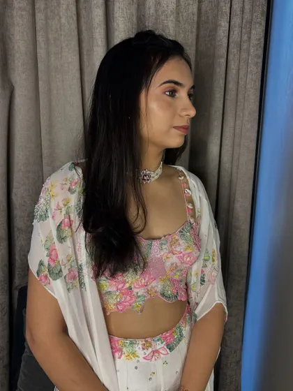 A soft and pretty look for a wedding guest. The makeup is very natural, focusing on pink tones to match her floral outfit.