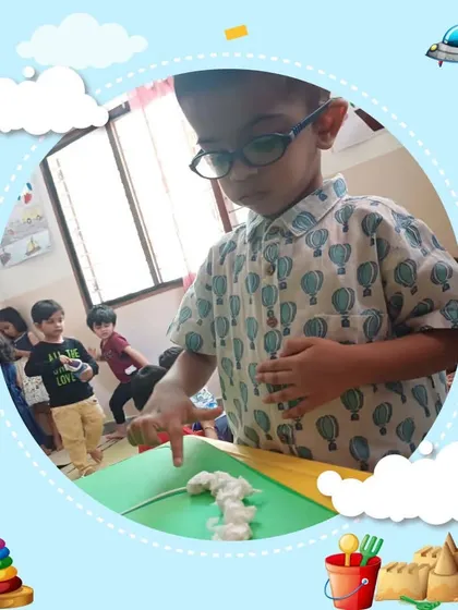 A child intently focuses on a hands-on phonics activity, using his finger to trace a letter. We use tactile methods to help children discover how sounds and words are formed.