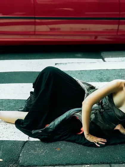 A daring shot on a crosswalk in Tokyo. The red car adds a pop of color and a sense of danger, making the image feel dynamic and alive.